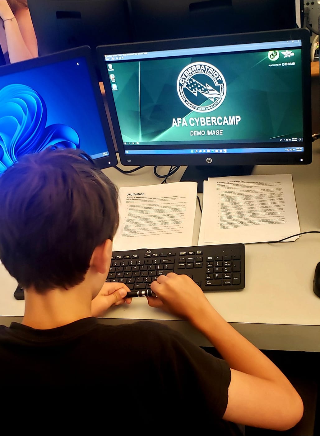 Cadet working at a computer during AFA CyberCamp cybersecurity training