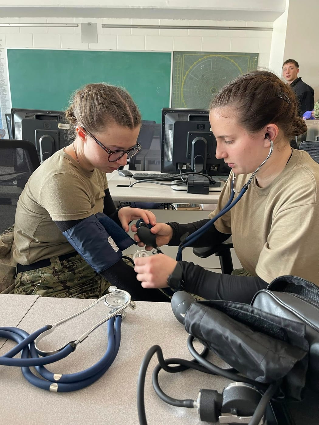 Two cadets practicing first aid and blood pressure measurement during medical training