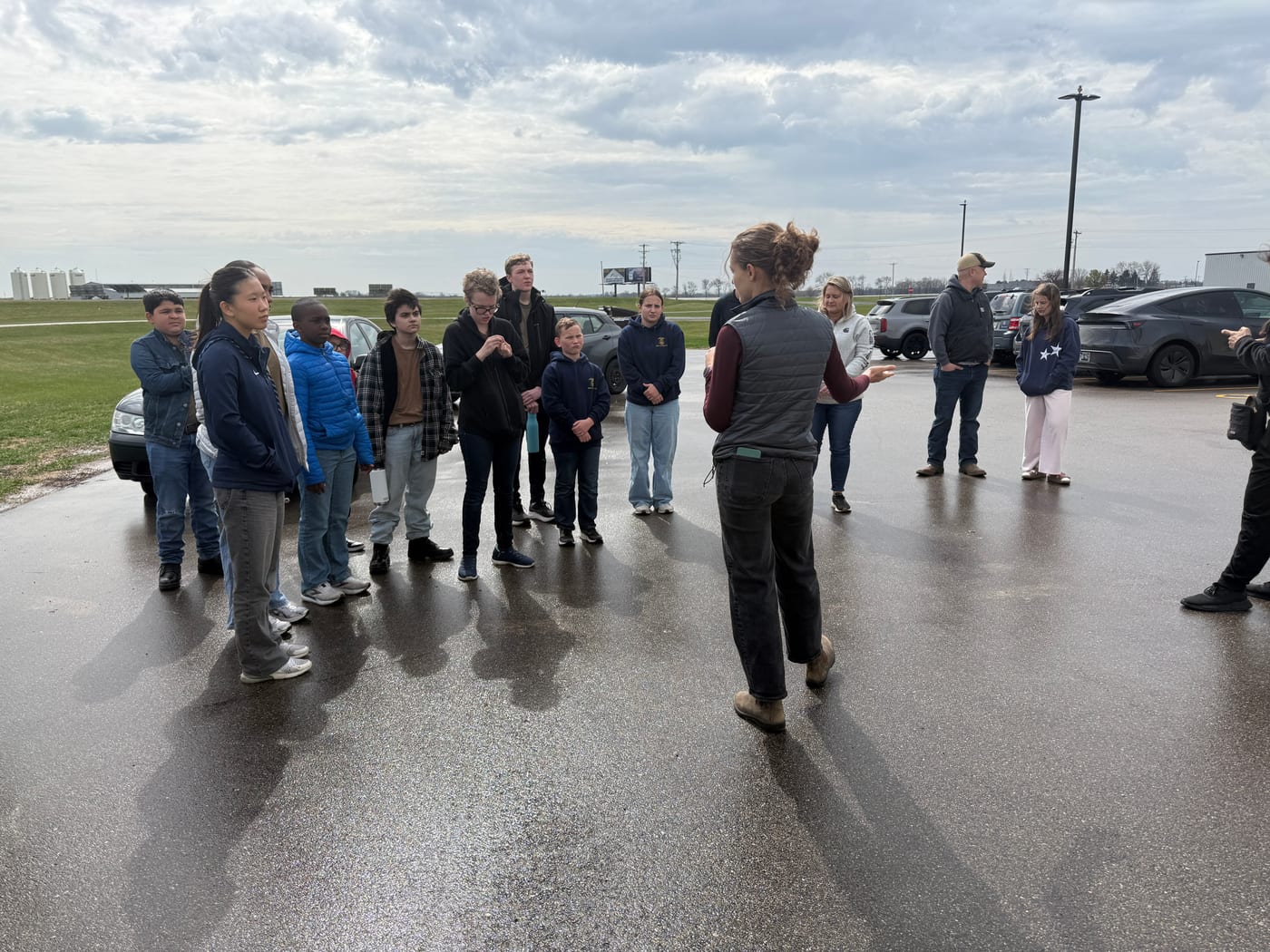Cadets gathered outdoors listening to an instructor brief them before a field activity