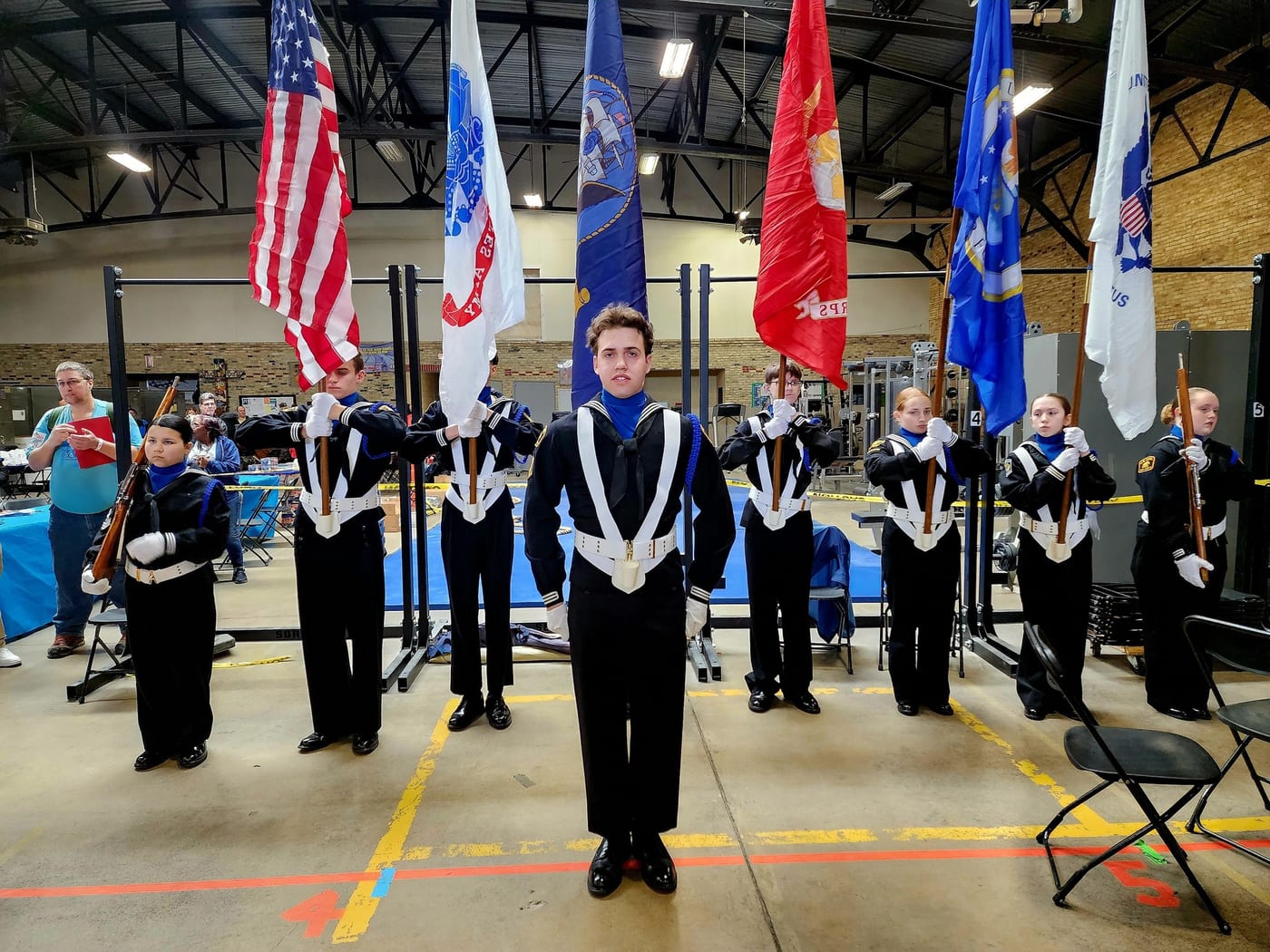 Cruiser Milwaukee color guard cadets standing at attention in Navy Working Uniform