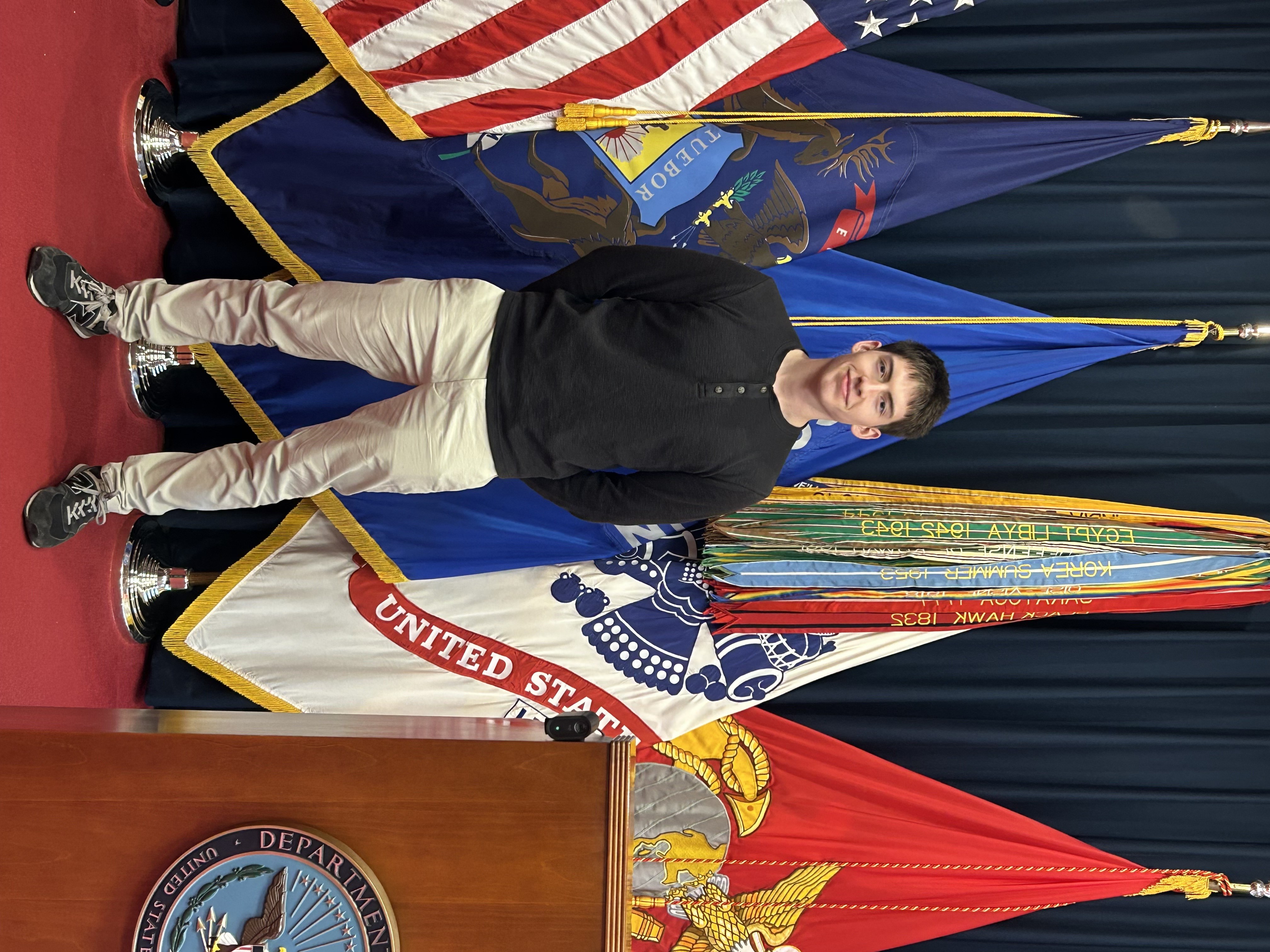 Mitchell King standing in front of military service flags