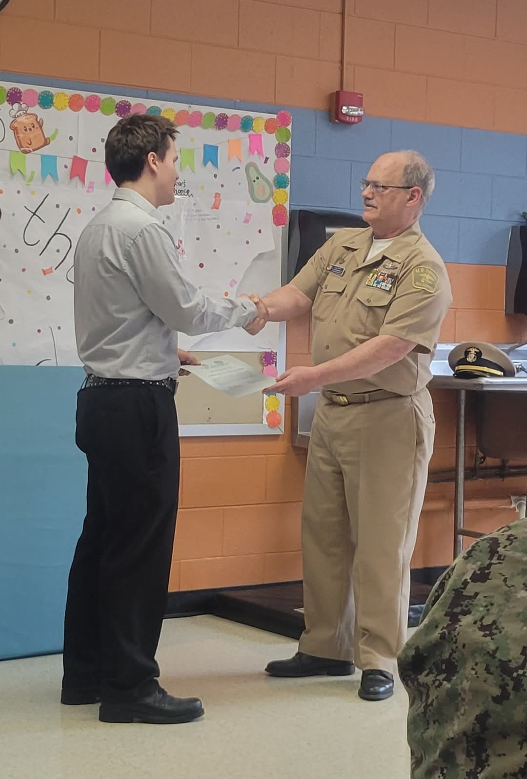 Karl Williams receiving a certificate from a commanding officer