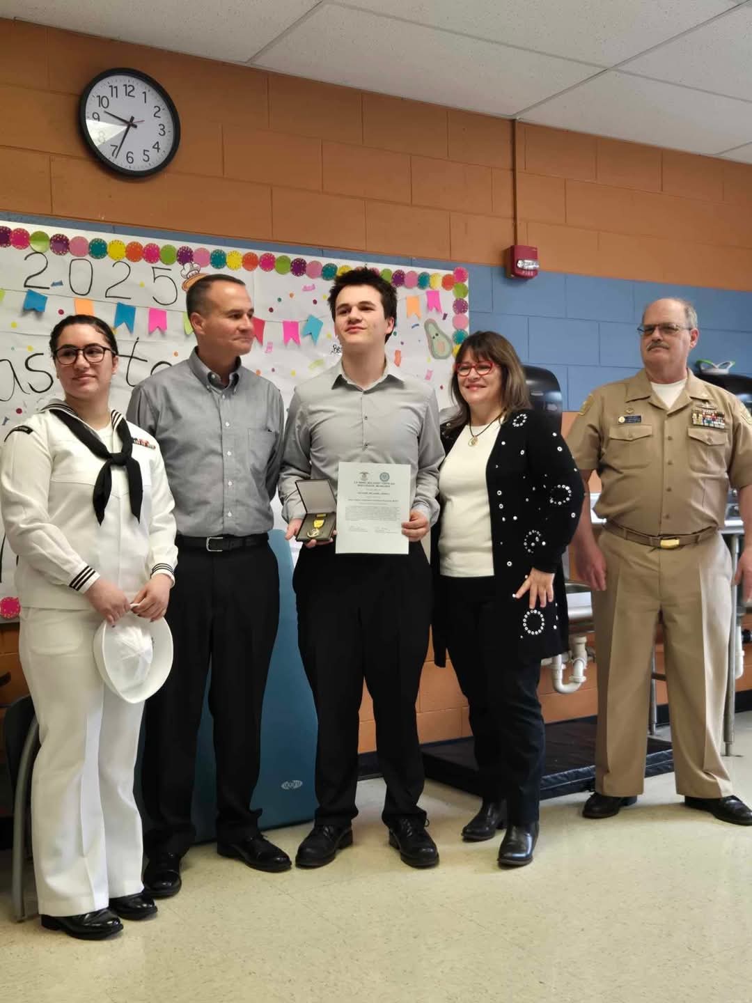 Karl Williams receiving an award with his family and commanding officer